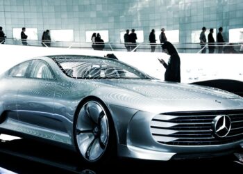 man in black suit standing beside silver mercedes benz coupe